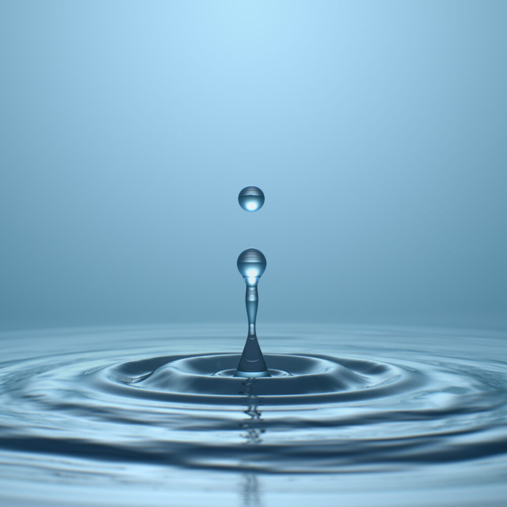 Water drop with droplet and rings on surface bluish background